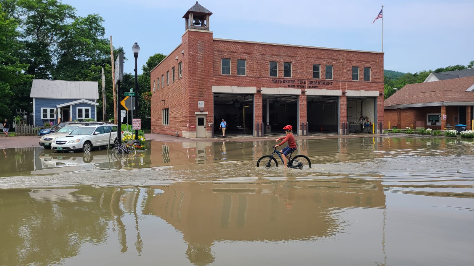 Child bikes through flooded street