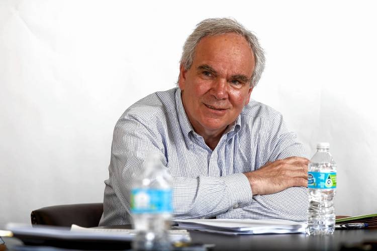 A man sitting at a table with water bottles.