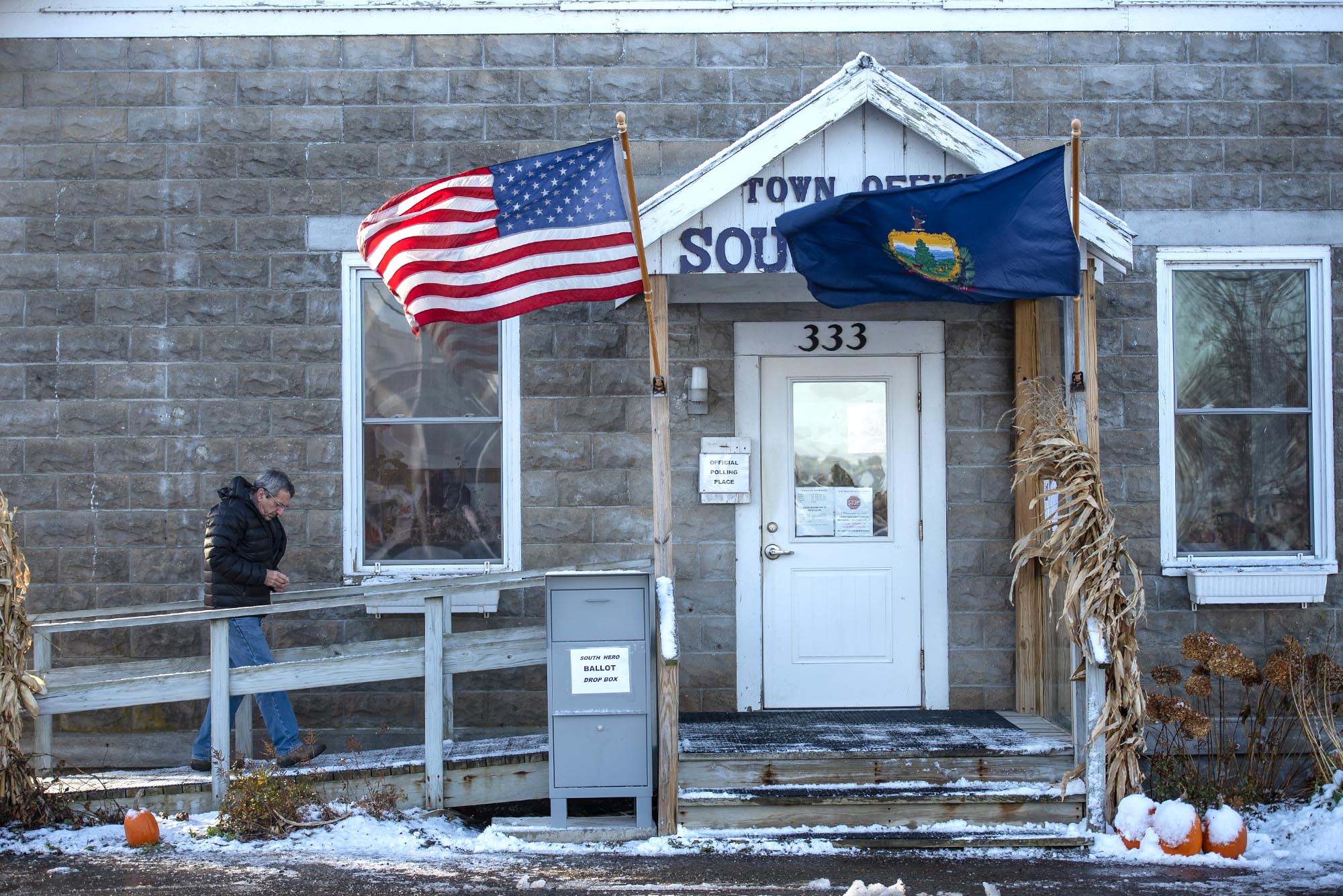 A cinderblock building with American and Vermont flags flying in front.