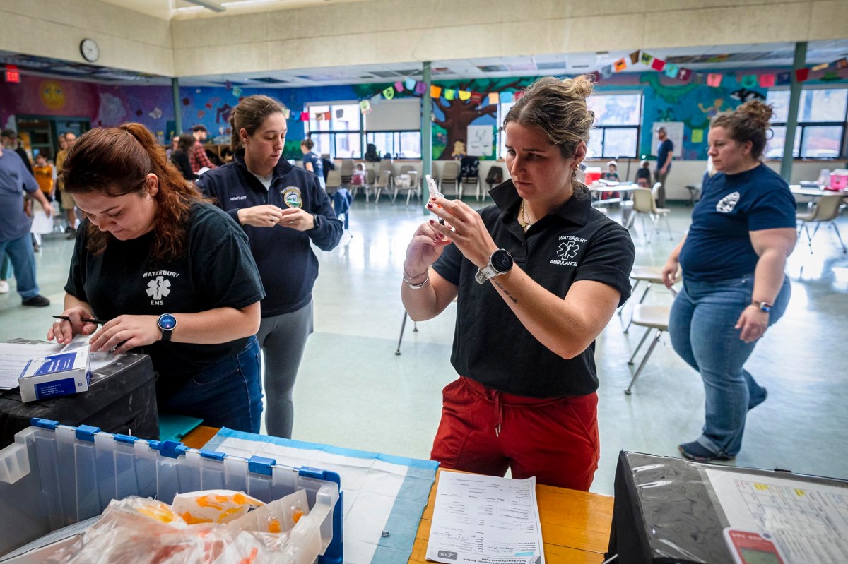 A group of people standing around a table in a classroom.